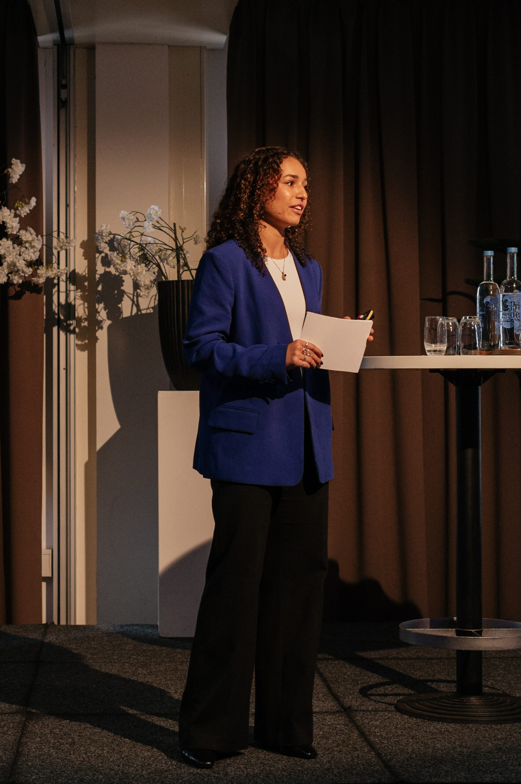 Coco Leysner als dagvoorzitter op het podium